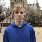 Tanner Laycock in a blue Nike hoodie in front of Sagrada Família, Barcelona